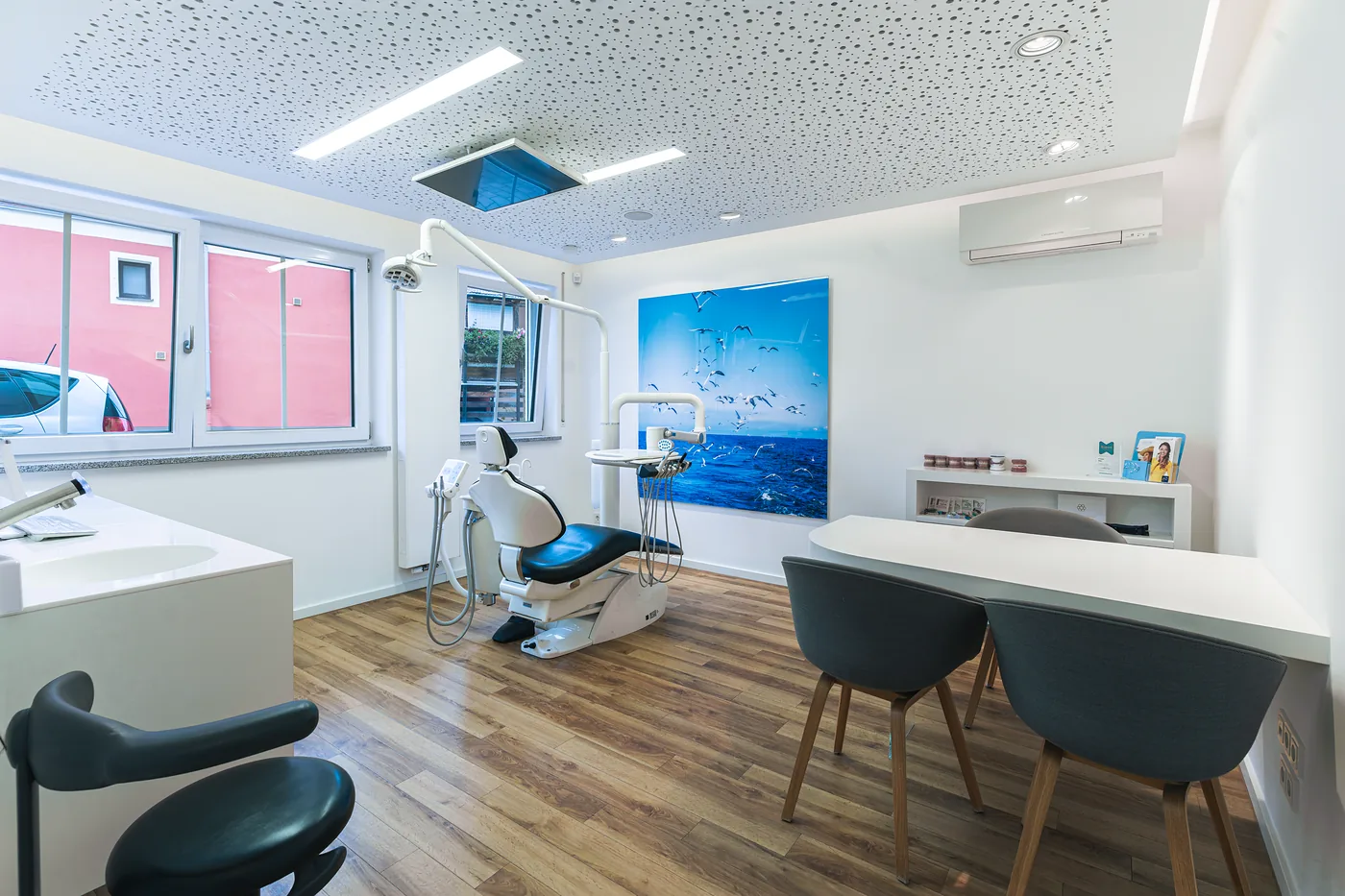 Behandlungszimmer mit Behandlungsstuhl und Beratungstisch