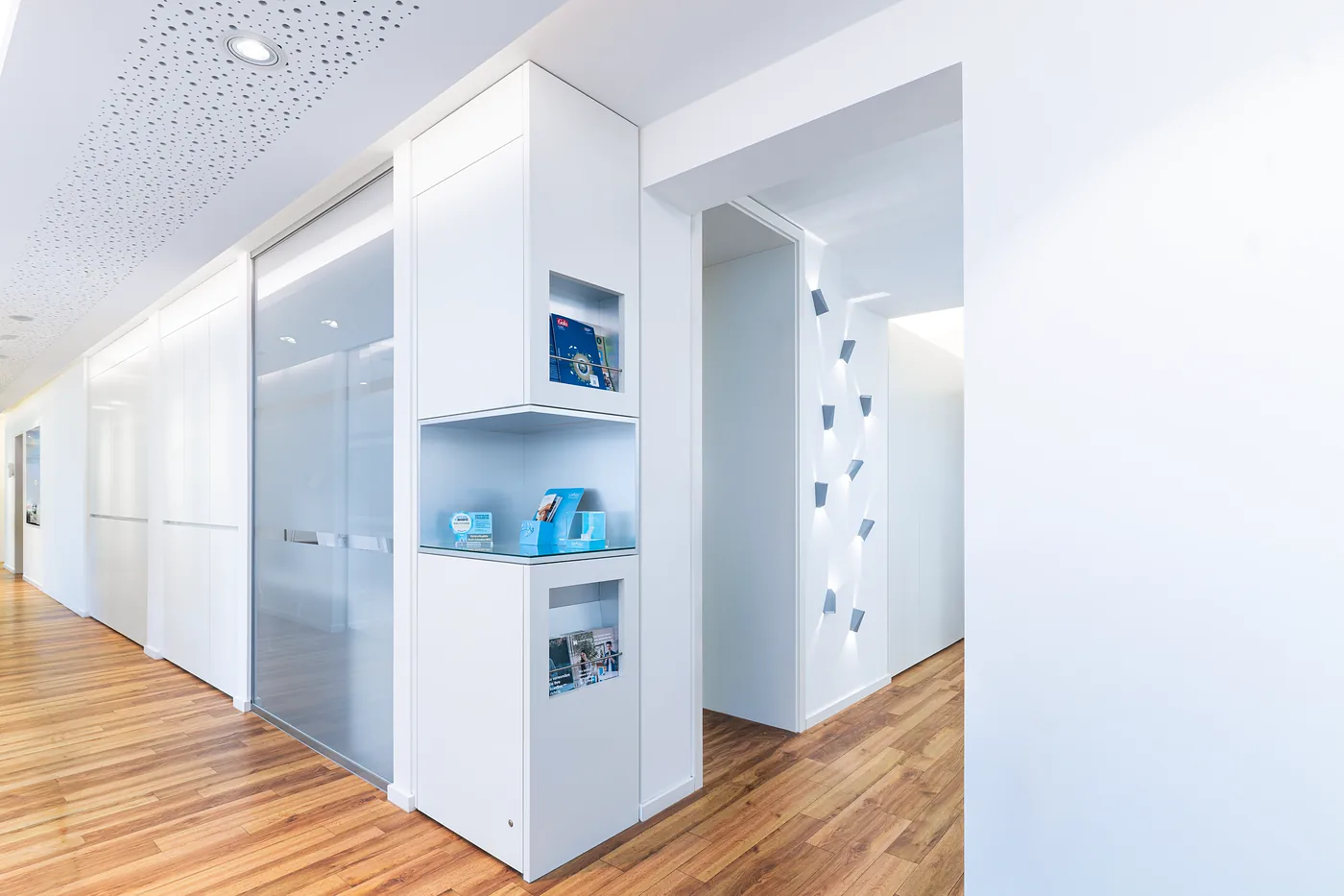 Heller Flur der Praxis mit Informationsvitrine
